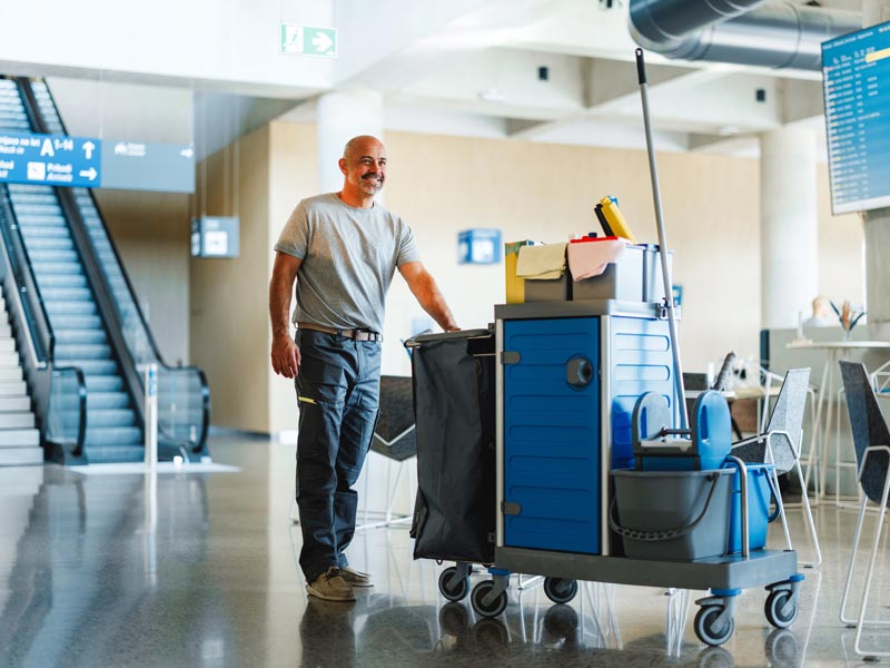 man pushing janitorial cart