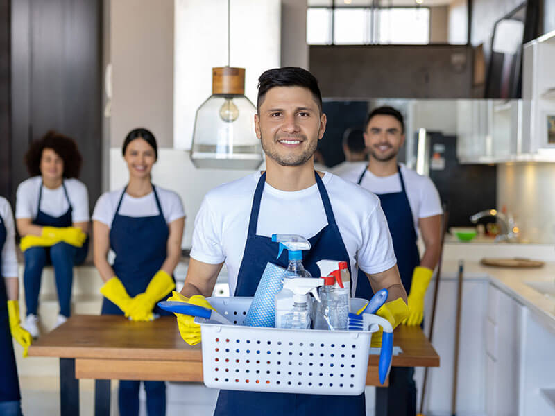 group of smiling workers that are cleaning home